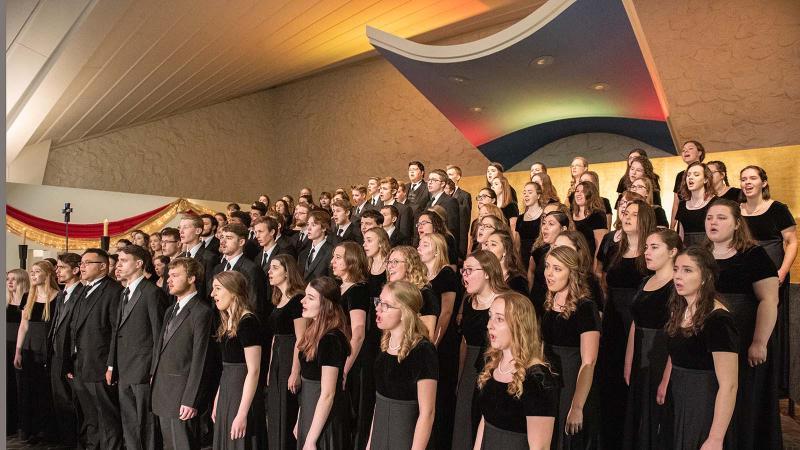 Large choral group performing in the Our Lady of the Annunciation Chapel